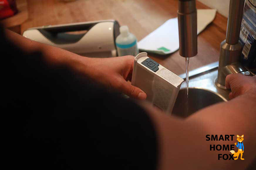 Man sieht, wie der Wassertank des Vorwerk VG100 mit Wasser befüllt wird. 